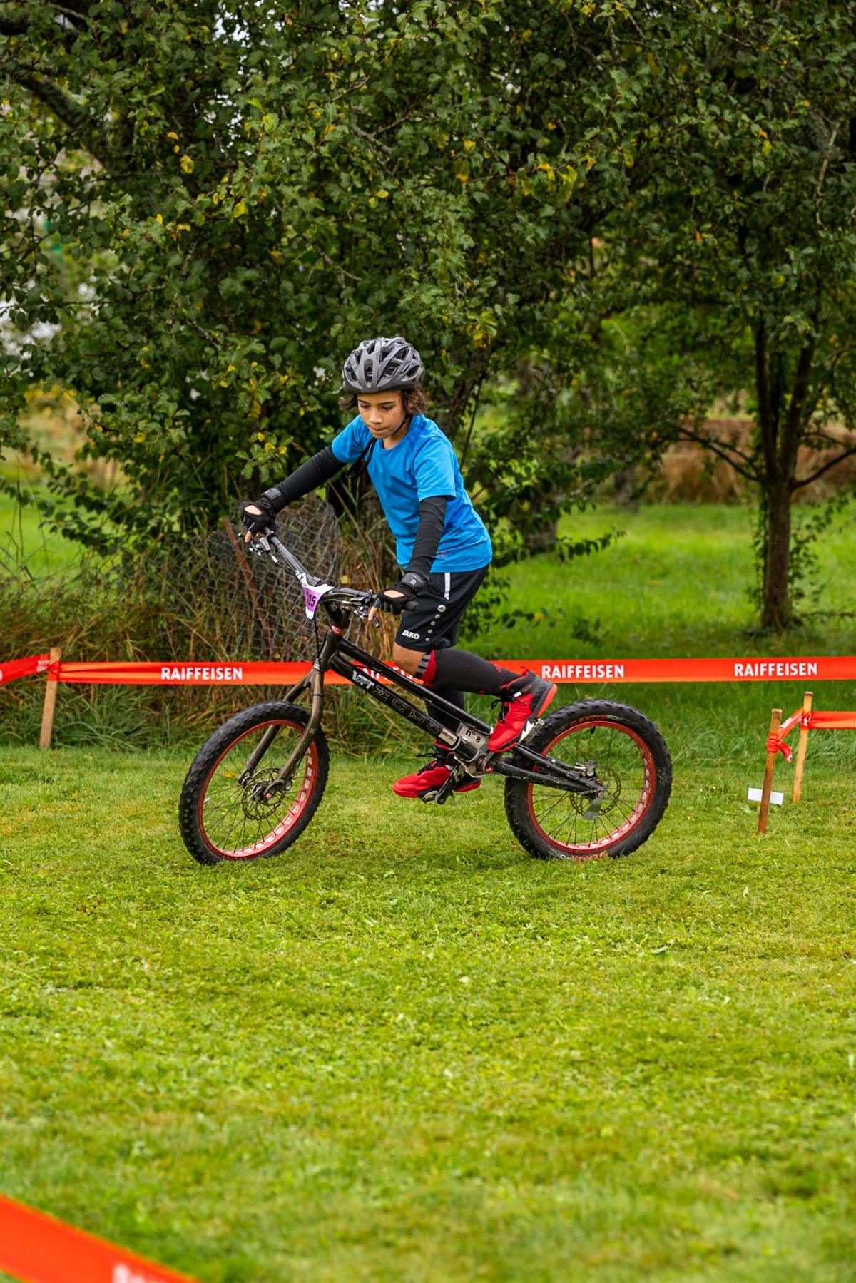 Michael Photographie Trail Days Vaud VTT jeune vélo dans l'herbe bleu et noir 